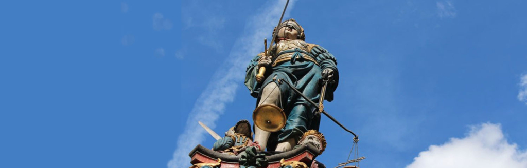 La fontaine de la justice, une statue tenant une épée et une balance.