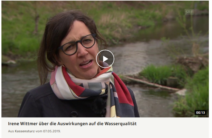 Une femme portant un foulard se tient à côté d'une rivière et raconte dans la vidéo les effets sur la qualité de l'eau.